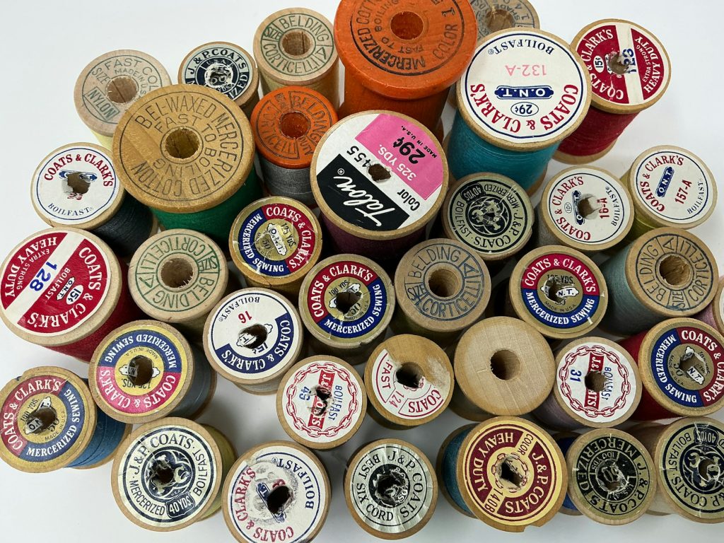 Ferramentas de costura e carretéis de linha em bancada de trabalho