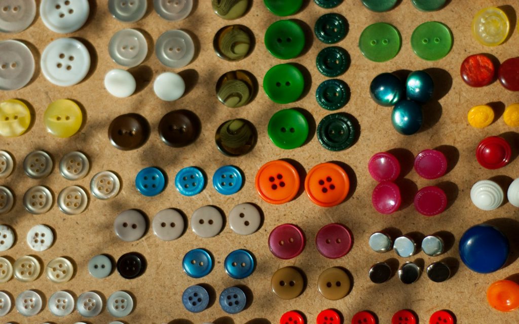 A bunch of different colored buttons on a table