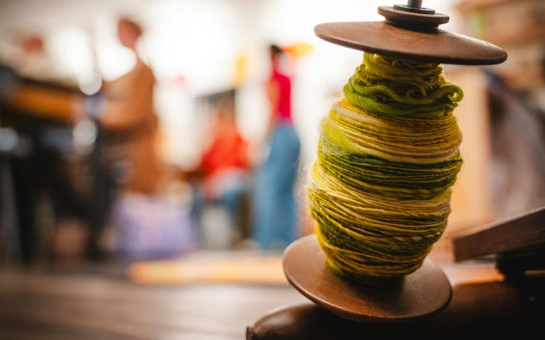 A spindle holds colorful, twisted yarn.