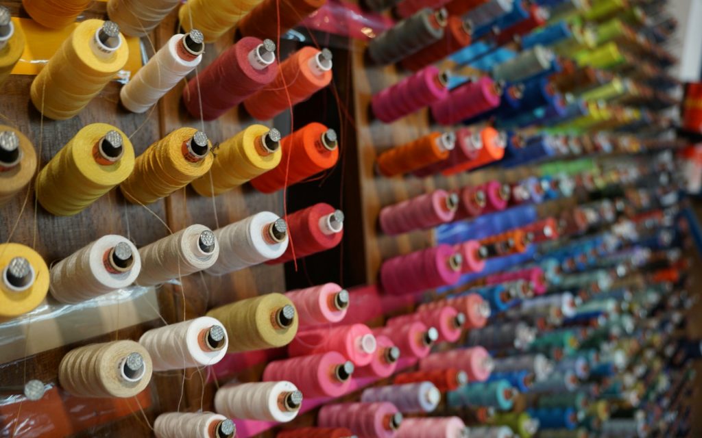 Wall of colorful spools of thread