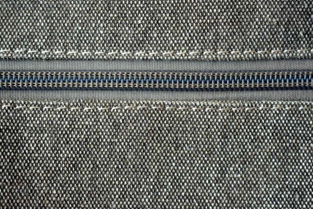 Zíper e tecido apoiados em mesa de costura